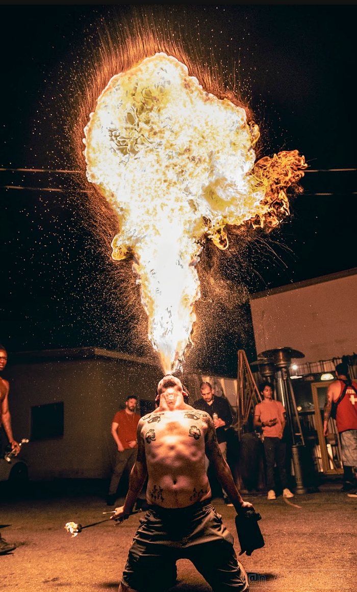 Fire breather sending a huge plume of flame straight up into the night
